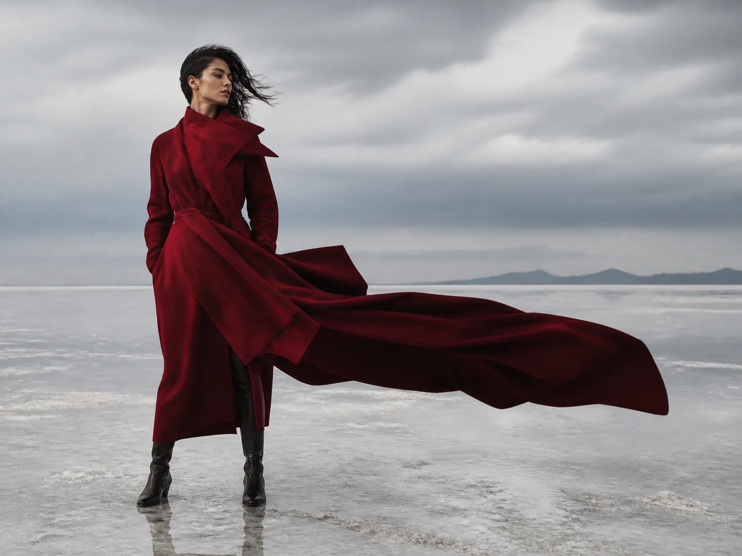 Model in a crimson architectural coat standing on a salt flat generated by Video Studio AI